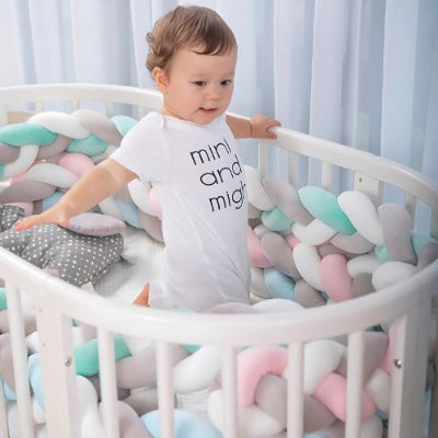 Bébé serein dans son lit entouré de tour de lit tresse respirant avec tressage aéré pour une circulation optimale de l’air