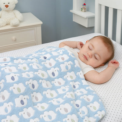 Bébé dort paisiblement couvert de la couverture bébé bleu à motifs 