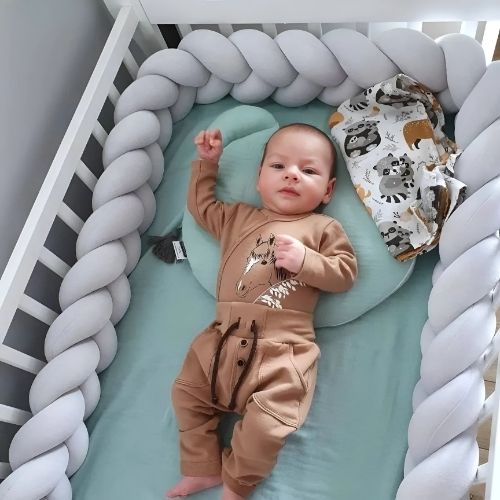 Bébé dans un berceau entouré d'une tresse de lit bebe pour un confort inégalé