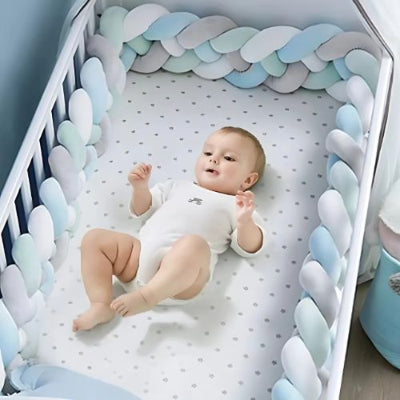Bébé heureux allongé dans un berceau entouré d'une tresse de lit bebe élégante